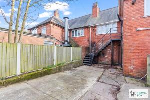a brick house with a wooden fence and a gate at Abbie's House in Nottingham