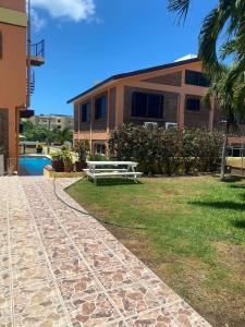 un banco sentado en el césped frente a un edificio en Brisa Suave Studio Suite, en Punta Mita