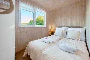 a bedroom with a large white bed with towels on it at Turkusowa Osada - family resort in Wapnica