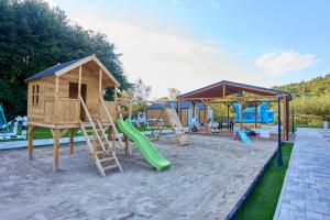 a playground with a slide and a play house at Turkusowa Osada - family resort in Wapnica