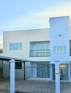 a white building with a fence in front of it at Ap conforto no centro de Sinop 2 in Sinop