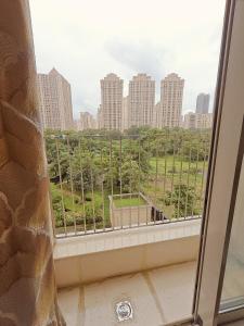 a window with a view of a city at Thane's First Hidden door studio - Hiranandani Estate in Thane