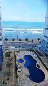 een uitzicht op het strand en de oceaan vanuit een gebouw bij Ape Condomínio Club - pé na areia in Mongaguá