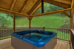 Un jacuzzi en una terraza con techo en Gorgeous "Country Roads" by HoneyBearCabins 4BR 4BA, next to pool, easy drive, main strip location!, en Pigeon Forge 36 fotos más
