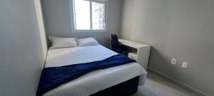 een kleine slaapkamer met een bed en een raam bij Ape Condomínio Club - pé na areia in Mongaguá +25 foto's