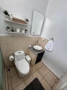 een badkamer met een toilet, een wastafel en een spiegel bij Chill House 