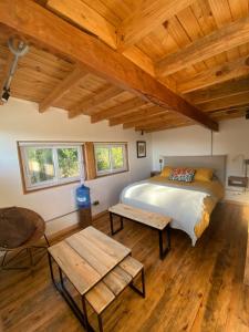 Un dormitorio con una cama y un techo de madera. en Paz y tranquilidad en un bello entorno, en Buchupureo