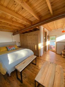 a bedroom with a bed and a wooden floor at Paz y tranquilidad en un bello entorno in Buchupureo