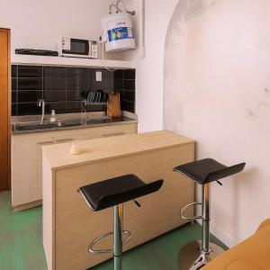 una cucina con due sgabelli da bar di fronte a un bancone di Miatello a Villa Nueva