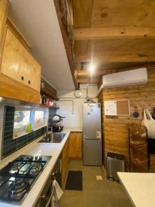 a small kitchen with a refrigerator and a sink at Paz y tranquilidad en un bello entorno in Buchupureo +14 photos