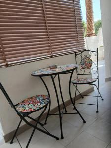 a table and two chairs sitting next to a window at levante rooms in Scalea