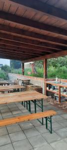 a group of wooden benches sitting under a roof at Pełen Wypas - Dziadówka in Przeworno