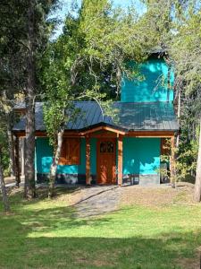 una casa con fachada azul y árboles en Ranel Bolsón, en El Bolsón
