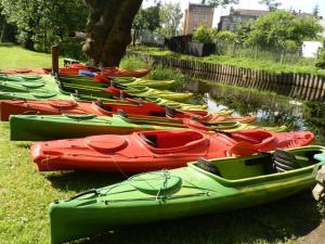 a group of kayaks lined up next to a body of water at Niebieski Domek in Gorzyca