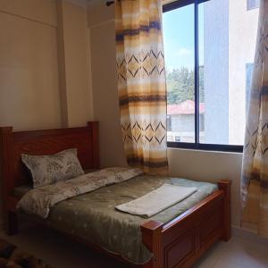 a bedroom with a bed and a large window at Ngong Home Stays in Ngong