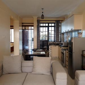 a living room with a couch and a kitchen at Ngong Home Stays in Ngong