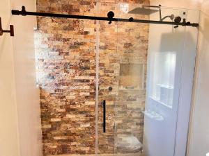 La salle de bains est pourvue d'une douche en verre avec un mur en briques. dans l'établissement Zihuatanejo Luxury Villa - Events & Vacations, à Zihuatanejo 29 autres photos