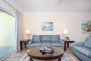 格尔夫海岸Crystal Shores West 807 condo的客厅里有一张沙发和一张桌子。
