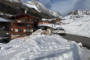 a ski lodge with a car parked in the snow at Location Appartement - Le grand Bornand Chinaillon - Pied des pistes in Le Chinaillon +4 photos