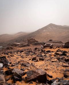 a rocky area with rocks and mountains in the background at Desert Erg Camp Merzouga in Merzouga