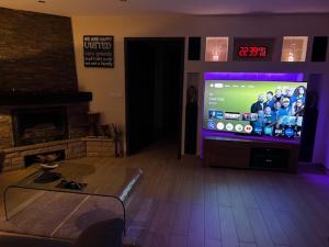 a living room with a large television with a football game at chez Kay in Vétraz-Monthoux