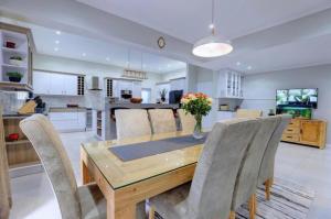 a kitchen and dining room with a wooden table and chairs at Pinnacle Golf Estate Haven in Mossel Bay