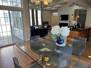 GlencarlynにあるGorgeous Spacious Home 5BR 9Beds with Private Parkingのリビングルーム(花の飾られたガラスのテーブル付)