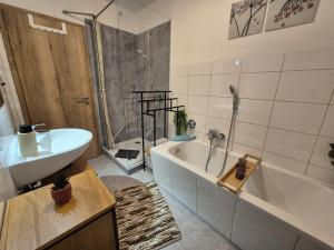 a bathroom with a tub and a sink and a bath tub at Evelyns Apartment Kurpark Idylle in Bad Bocklet +14 photos
