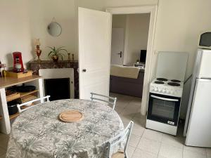 a kitchen with a table and a stove and refrigerator at Logement proche Zoo de Beauval in Écueillé