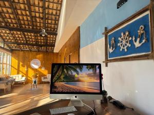 a computer monitor sitting on a desk in a room at Pousada Barra do Sahy in Barra do Sahy