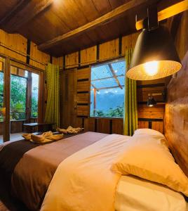 ein Schlafzimmer mit einem großen Bett in einem Zimmer mit Fenstern in der Unterkunft Eden Treehouse in Mindo