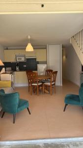 a living room with a table and chairs and a kitchen at Appartement au pied de la montagne in Guchen
