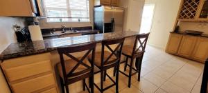 una cucina con bancone e 2 sgabelli da bar di # Pet Friendly # Overlooks Pool Sleeps Tons a South Padre Island