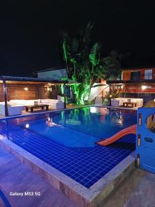 a pool at night with a water slide at Pousada Iwalu in Búzios