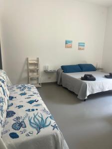 a bedroom with two beds and a table and a chair at Casa ISABELLA loc turist br in Lipari