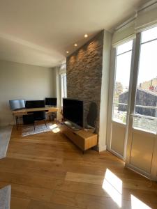 ein Wohnzimmer mit einem TV und einem Schreibtisch in der Unterkunft Villa Katerina - Luxury Apartment in Nizza