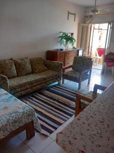 een woonkamer met een bank en twee stoelen bij Marseilia Resort 1 in Borg El Arab