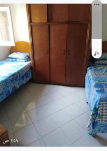 een slaapkamer met 2 bedden en een kast bij Marseilia Resort 1 in Borg El Arab