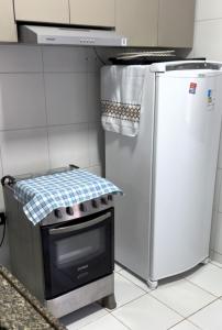 a kitchen with a stove and a refrigerator at Casa de Praia Encanto Tamandaré - A 300m das Piscinas Naturais in Tamandaré