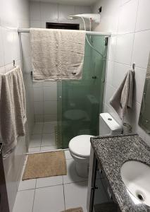 a bathroom with a shower and a toilet and a sink at Casa de Praia Encanto Tamandaré - A 300m das Piscinas Naturais in Tamandaré +6 photos