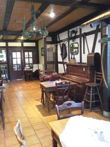 a room with a piano and tables and chairs at Landhotel zur guten Quelle in Eisenach