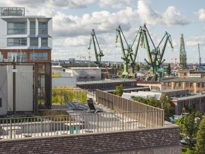 a view of a city with cranes in the background at LILY APART - Foodhall & Rooftop Terrace in Gdańsk