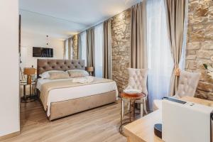 a bedroom with a bed and a stone wall at Four Elements - Water & Earth in Split +12 photos