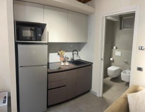 eine kleine Küche mit Spüle und Kühlschrank in der Unterkunft Smartroom Lula di Correggio in Correggio