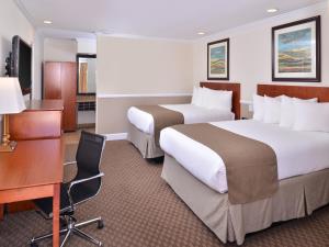 a hotel room with two beds and a desk at Best Western Capistrano Inn in San Juan Capistrano