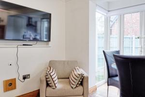 a living room with a chair and a tv at Quirky 2-Bed Brentwood Home Near High St & Station - With Parking in Brentwood