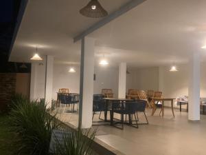 a patio with a table and chairs and lights at Foca Guest House in Búzios