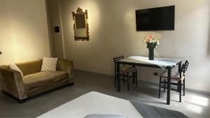 a living room with a couch and a table and a television at Smartroom Lula di Correggio in Correggio