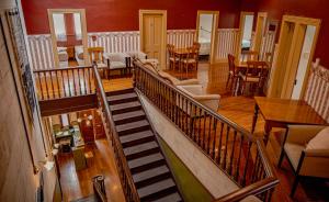 a staircase in a living room with chairs and tables at Criterion Boutique Hotel in Oamaru