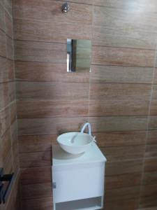 a bathroom with a sink and a mirror on a wall at Suite Jockey 1 in Campos dos Goytacazes